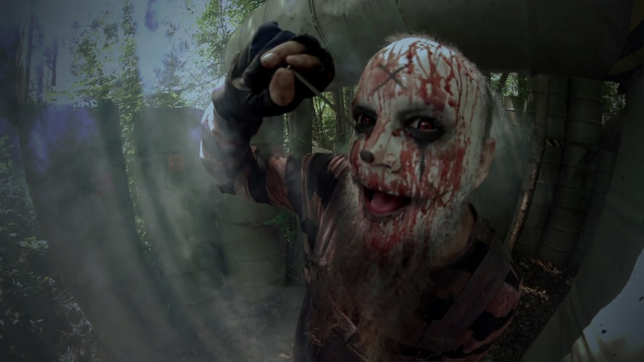 A blood-streaked clown lunging through the smoke in the Field of Screams barrel maze, from the 2026 commercial